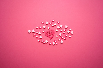 Valentines day copy space. Pink and red Heart shape beads on pink background. 