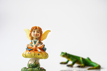 Fairy is sitting on mushroom while being stalked by a lizard.