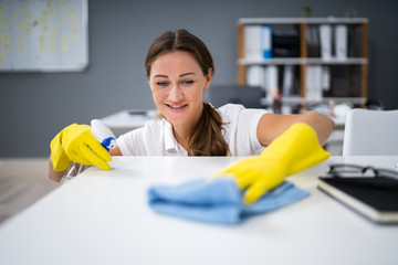 Worker Cleaning Desk With Rag