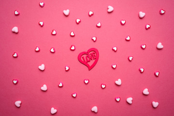 Valentines day copy space. Pink and red Heart shape beads on pink background. 