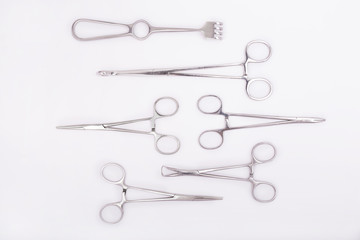 Metal surgical instruments on white background. Plastic surgical instruments. Flat lay