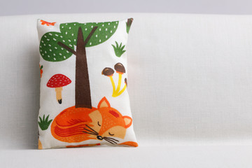 Cushion with sleeping fox on sofa and copy space