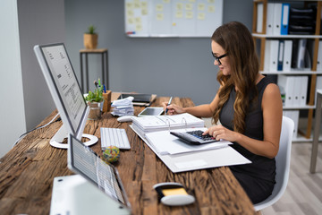Accountant Calculating Tax At Desk