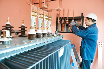 Electrician lineman worker installing power industrial transformer - obrazy, fototapety, plakaty