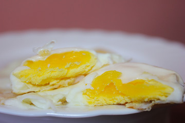 Fried eggs close-up. Photo of a delicious Breakfast on a white plate, two yolks and a white