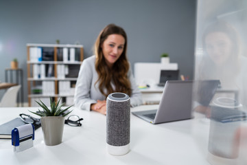 Woman Listening To Music On Wireless Speaker