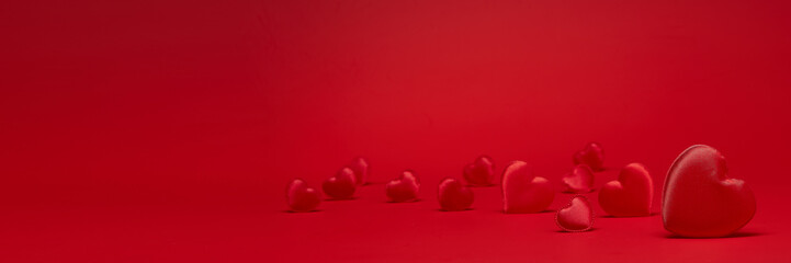 Group of silk red hearts (rendom scatter) on red background with copy space. Hearts background....