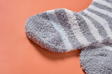 Pair of striped soft and warm socks on orange background. Space for text