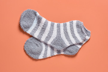 Pair of striped soft and warm socks on orange background. Top view. Close-up