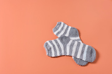 Pair of striped soft and warm socks on orange background. Space for text. Top view