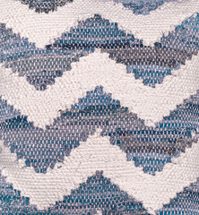 Zig zag fabric pattern. Pillow or carpet close. Rug rag weaving. White and blue. 