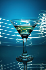 a glass of martini on a blue background