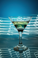 a glass of martini on a blue background