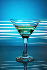 a glass of martini on a blue background