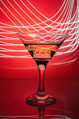 a glass of martini on a red background