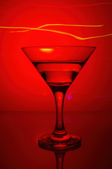 a glass of martini on a red background