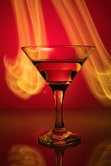 a glass of martini on a red background