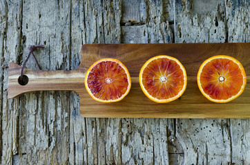 Sliced blood oranges on wooden board