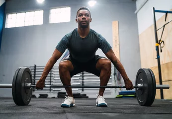 Fotobehang Sportschool Crossfit athlete doing exercise with a barbell.  © Mego-studio