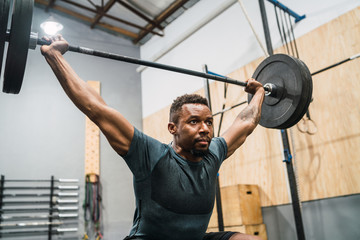 Crossfit athlete doing exercise with a barbell.
