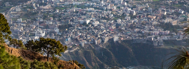 Beautiful city scape shot from a mountain top with a deep valley in the middle and jungle in the left.