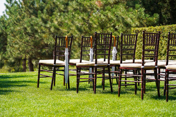 Rows of chairs for guests at an open-air wedding ceremony.