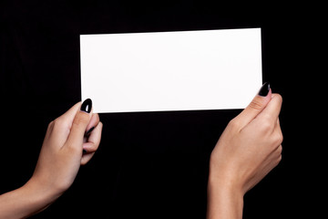 hands holding white card on black background - copyspace