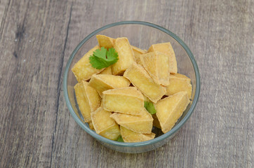 A glass bowl of fried tofu cubes