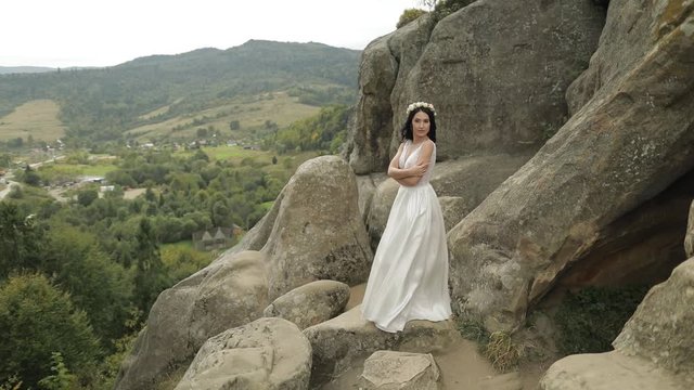 Beautiful and lovely bride standing on the mountain hills. Woman in love