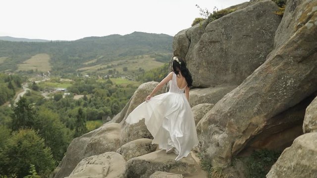 Beautiful and lovely bride standing on the mountain hills. Woman in love