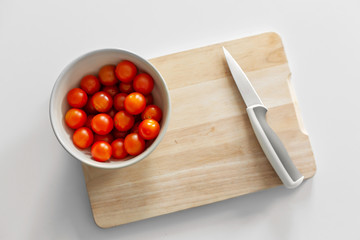 A bowl of cherry tomatoes on a cutting board. Cooking healthy and tasty food