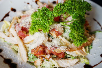 High angle top view on Caesar salad served in a white plate fresh with some parsley