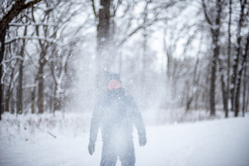 Man throwing snow into the air on cold wintry day