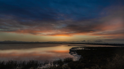 Sunrise into the clouds over the marsh wetlands off highway 37 in Vallejo Ca.