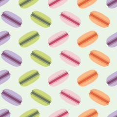 Seamless vector pattern with zigzag lines of colorful French macarons in purple, green, pink, and orange on a pale mint green background. Fun food illustration for fabric, paper goods, gifts.