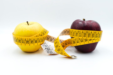 Dieting concept apples and yellow tape measure isolated on white. Start a diet today concept