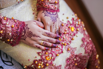 Very beautiful and unique henna paintings are on both hands of the bride.
