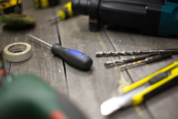 Tools on the table.  On the table is: duct tape, a screwdriver, drills on concrete, a knife for...