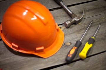 Tools on the old table.  On the table is: helmet, hammer, screwdriver.