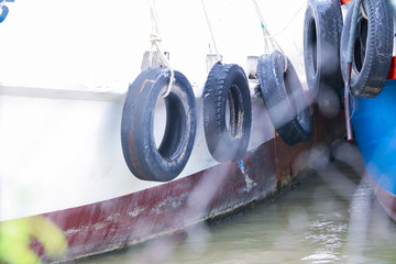 Old tires used to protect the sides of the fishing boat