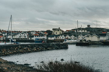 Vrångö, Southern Gothenburg Archipelago / Sweden - A view of sea shore, a rocky landscape of Vrångö island and its scandinavian wooden houses in Sweden during a cloudy day.