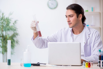 Young male chemist working in the lab