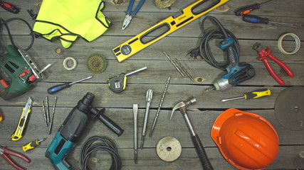 A variety of electro and hand tools and special clothing. Top view.  On the table are tools for...