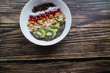 Smoothie bowl with organic ingredients on wooden table. Copy space. Top view.