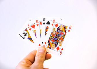 Hand holding a flush of Jack and Queen cards of poker over a white background