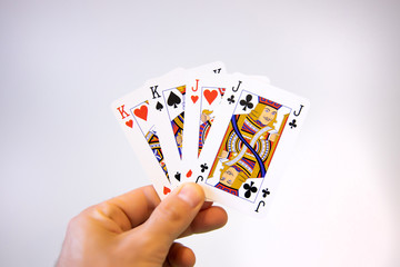 Hand holding a double pair of King and Jack cards of poker over a white background