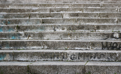 steps of a concrete staircase on the street - vintage dirty texture with graffiti