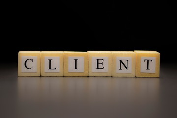 The word CLIENT written on wooden cubes isolated on a black background