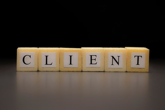 The word CLIENT written on wooden cubes isolated on a black background
