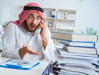 Arab businessman working in the office doing paperwork with a pi